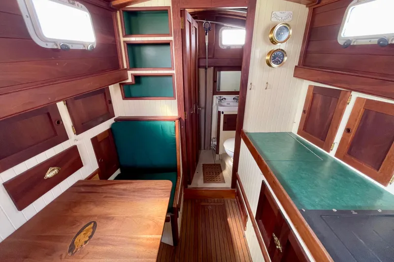 Slide: The Image of Cozy 2008 Pinky Custom boat interior with wood finish, dining area, and compact bathroom. - 20