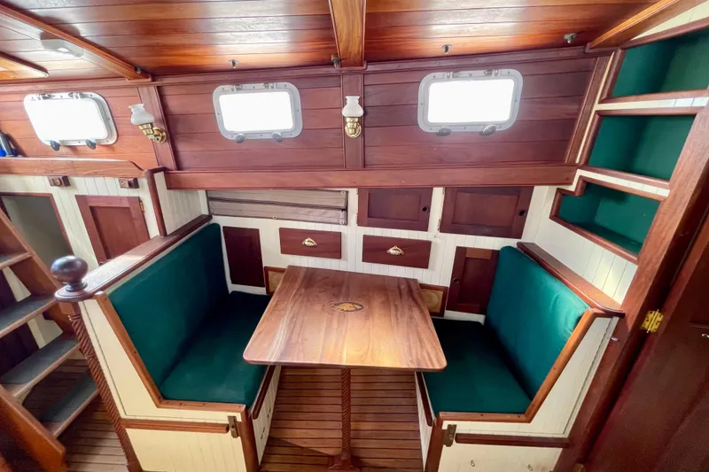 Slide: The Image of Cozy wooden boat interior with green cushioned seating, table, and storage, Pinky Custom 2008 model. - 22