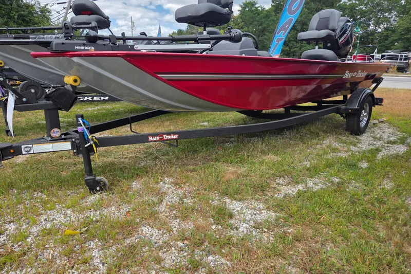 Slide: The Image of 2026 Tracker BT CLASSIC XL boat on trailer, red and gray design, parked on grass. - 2