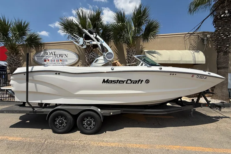 The Image of 2019 MasterCraft X24 boat on trailer, parked at Boat Town dealership. - 1