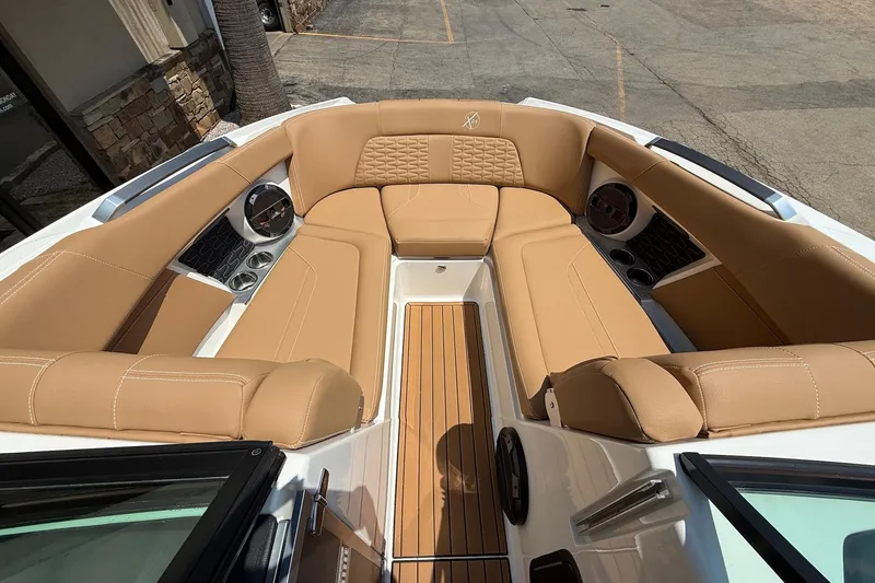 Slide: The Image of 2019 MasterCraft X24 boat interior with tan leather seating and wood flooring. - 13