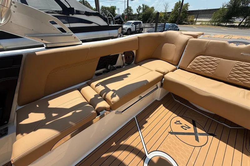 Slide: The Image of 2019 MasterCraft X24 boat interior with tan leather seating and teak flooring. - 14