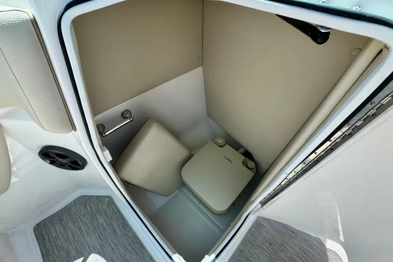 Slide: The Image of 2018 Regal 23 OBX boat interior with compact marine toilet and beige upholstery. - 27