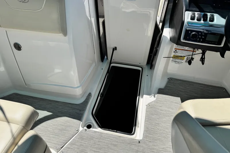 Slide: The Image of 2018 Regal 23 OBX boat interior with open storage compartment and control panel. - 28