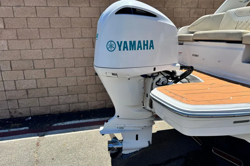 Slide: The Image of 2018 Regal 23 OBX boat with Yamaha outboard motor, docked near a brick wall. - 6