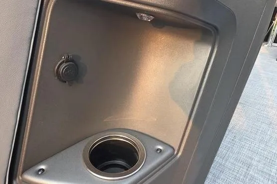Slide: The Image of 2026 Sun Tracker PB 20 DLX boat cup holder and power outlet detail. - 7