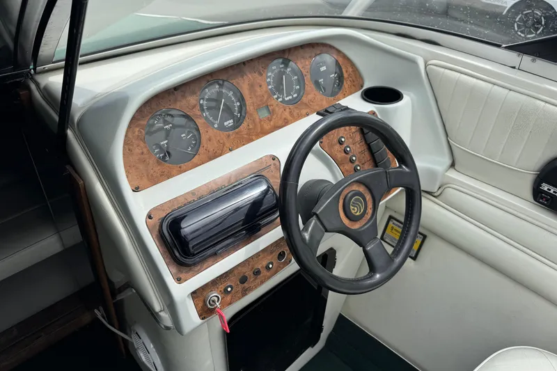 Slide: The Image of Interior of a 1995 Celebrity 220 BR boat, featuring a classic dashboard and steering wheel. - 10