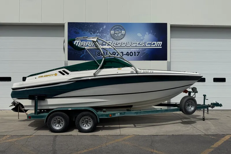 Slide: The Image of 1995 Celebrity 220 BR boat on trailer, parked outside marine products store. - 14