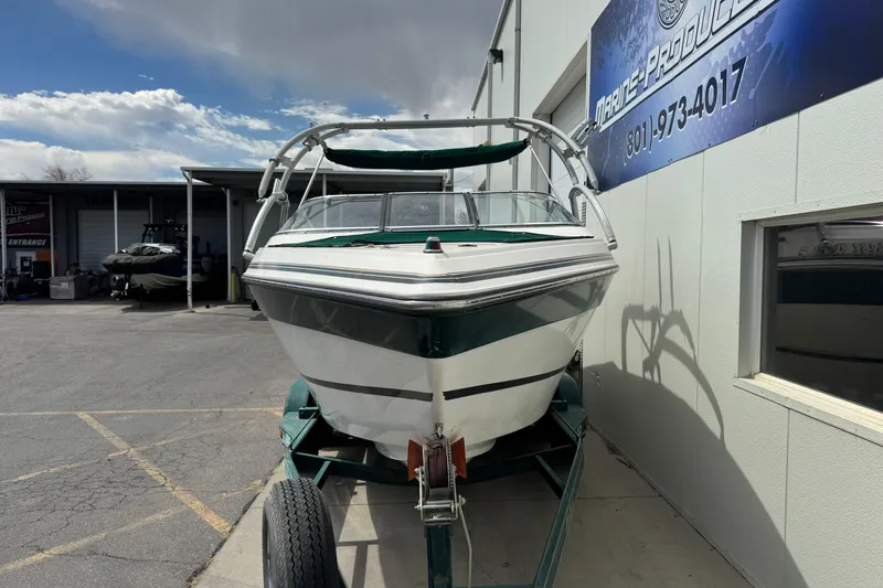 Slide: The Image of 1995 Celebrity 220 BR boat on trailer outside marine products store. - 3