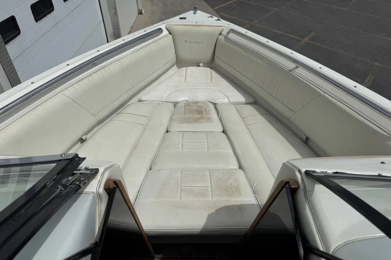 Slide: The Image of Interior of a 1995 Celebrity 220 BR boat with white seating and open bow area. - 6
