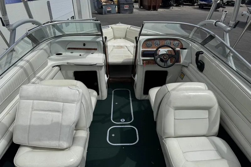 Slide: The Image of Interior of a 1995 Celebrity 220 BR boat with white seating and dashboard. - 8