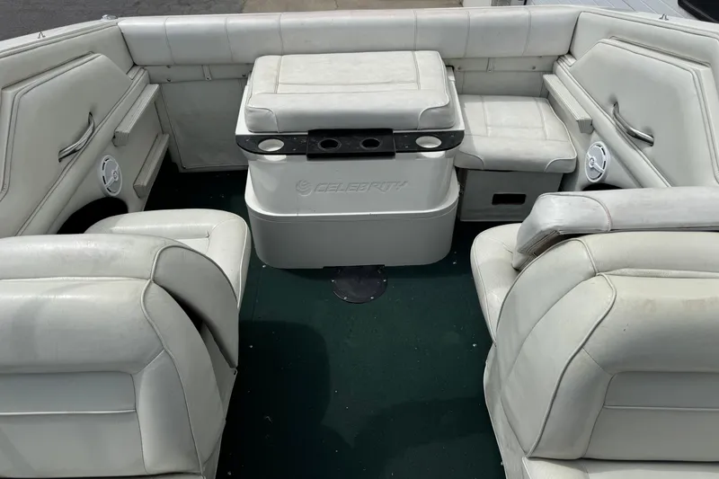 Slide: The Image of Interior of a 1995 Celebrity 220 BR boat with white seating and green carpet. - 9