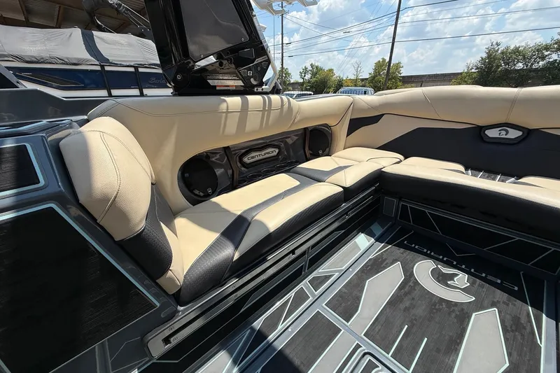 Slide: The Image of 2022 Centurion Ri245 boat interior with beige and black seating, featuring Centurion branding. - 14