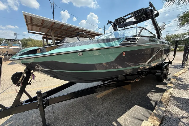 Slide: The Image of 2022 Centurion Ri245 boat on trailer, displayed outdoors under a sunny sky. - 4