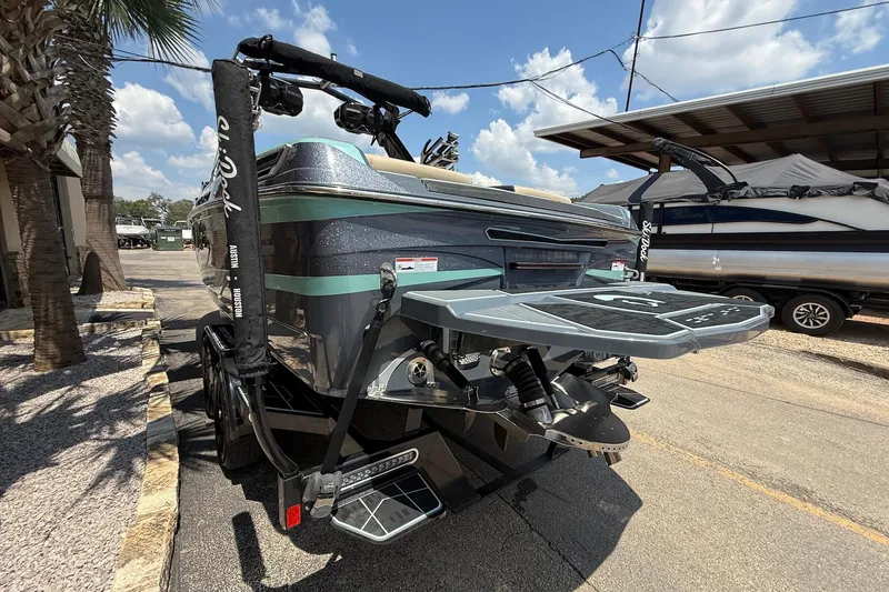 Slide: The Image of 2022 Centurion Ri245 boat with sleek design, parked outdoors under a sunny sky. - 5