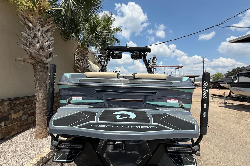 Slide: The Image of 2022 Centurion Ri245 boat with sleek design, parked under clear blue sky. - 6