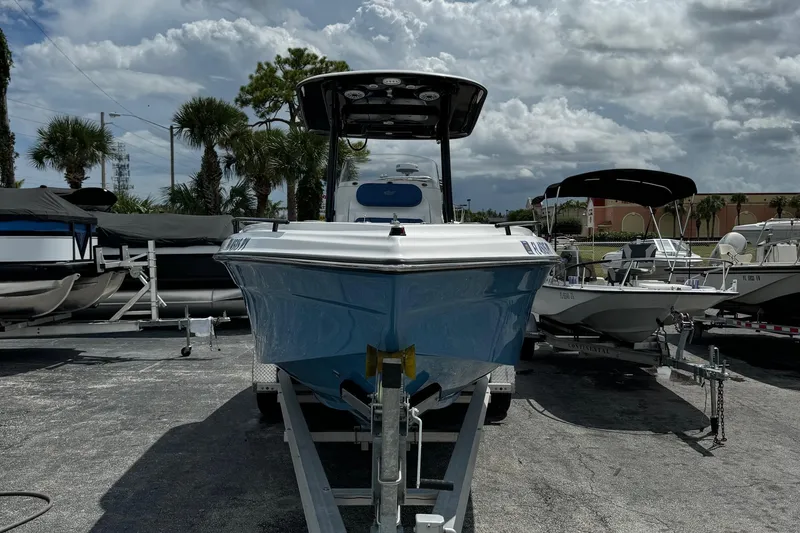 Slide: The Image of 2015 Glasstream 280 ZS boat on trailer, surrounded by other boats, under cloudy sky. - 2