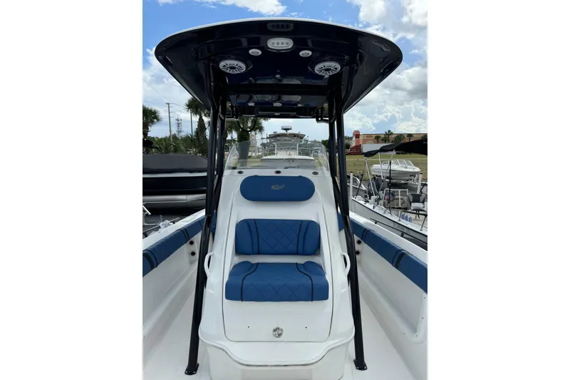 Slide: The Image of 2015 Glasstream 280 ZS boat with blue seating and T-top, docked under a cloudy sky. - 23