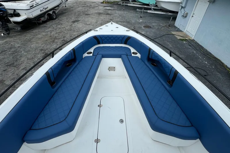 Slide: The Image of 2015 Glasstream 280 ZS boat interior with blue cushioned seating and storage compartments. - 25