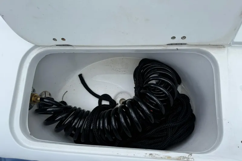Slide: The Image of Storage compartment on a 2015 Glasstream 280 ZS boat with coiled hose and rope. - 41