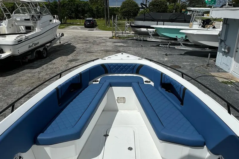 Slide: The Image of 2015 Glasstream 280 ZS boat with blue seating, docked among other boats. - 6