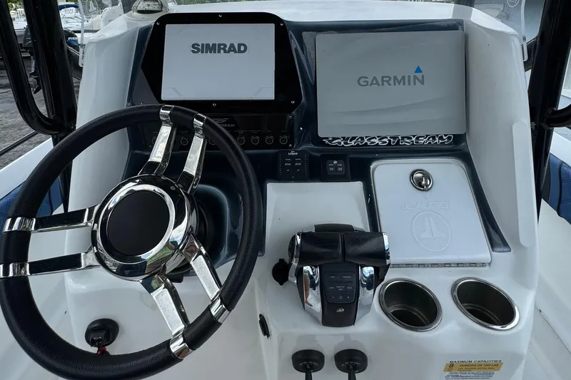 Slide: The Image of 2015 Glasstream 280 ZS boat dashboard with Simrad and Garmin displays, steering wheel, and controls. - 7