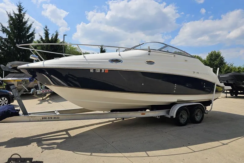 Slide: The Image of 2003 Regal Commodore 2665 boat on trailer under a sunny sky. - 14