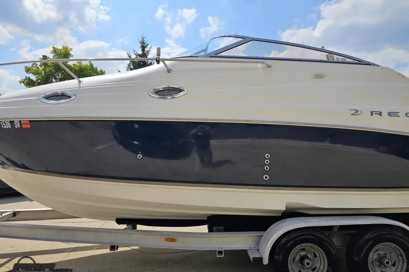 Slide: The Image of 2003 Regal Commodore 2665 boat on trailer under a blue sky. - 16