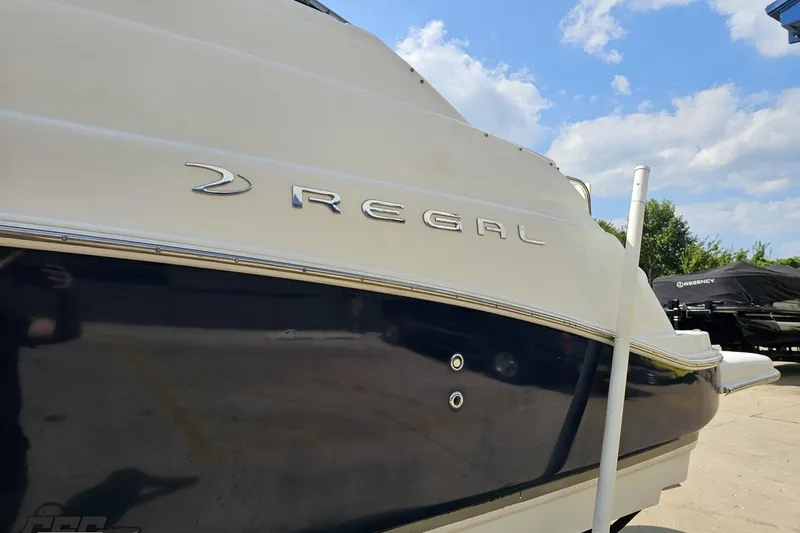 Slide: The Image of 2003 Regal Commodore 2665 boat, side view with logo, under a blue sky. - 19