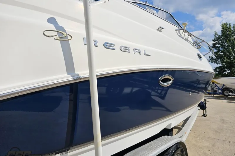 Slide: The Image of 2003 Regal Commodore 2665 boat on trailer, white and blue exterior. - 29