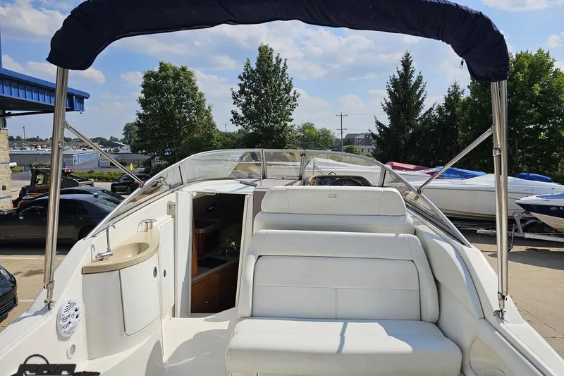 Slide: The Image of 2003 Regal Commodore 2665 boat interior with white seating and canopy, docked outdoors. - 31