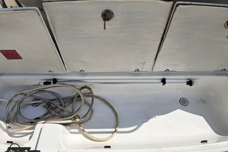 Slide: The Image of Storage compartment of 2003 Regal Commodore 2665 boat with coiled rope and metal rod. - 33