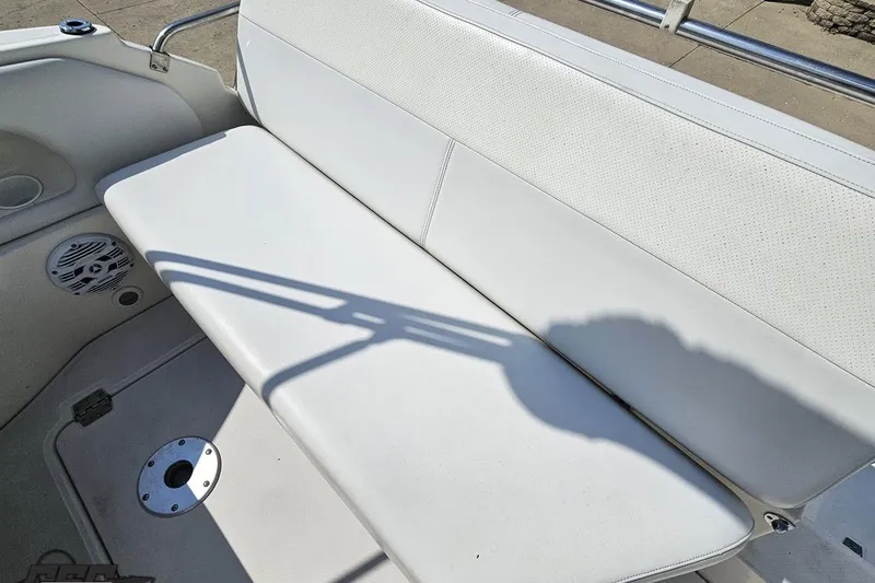 Slide: The Image of White seating area on 2003 Regal Commodore 2665 boat, featuring speaker and cup holder. - 39