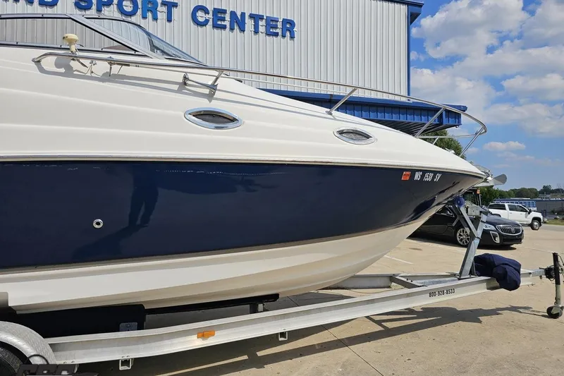 Slide: The Image of 2003 Regal Commodore 2665 boat on trailer at a sports center, under blue sky. - 4