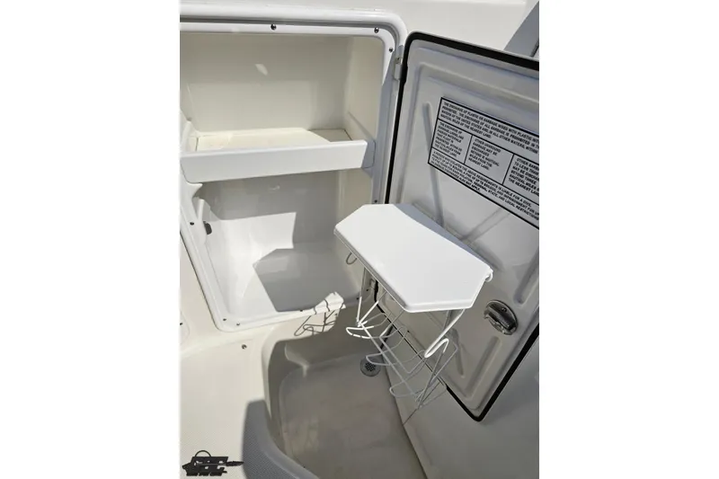 Slide: The Image of 2003 Regal Commodore 2665 boat interior storage compartment with open door and shelves. - 45