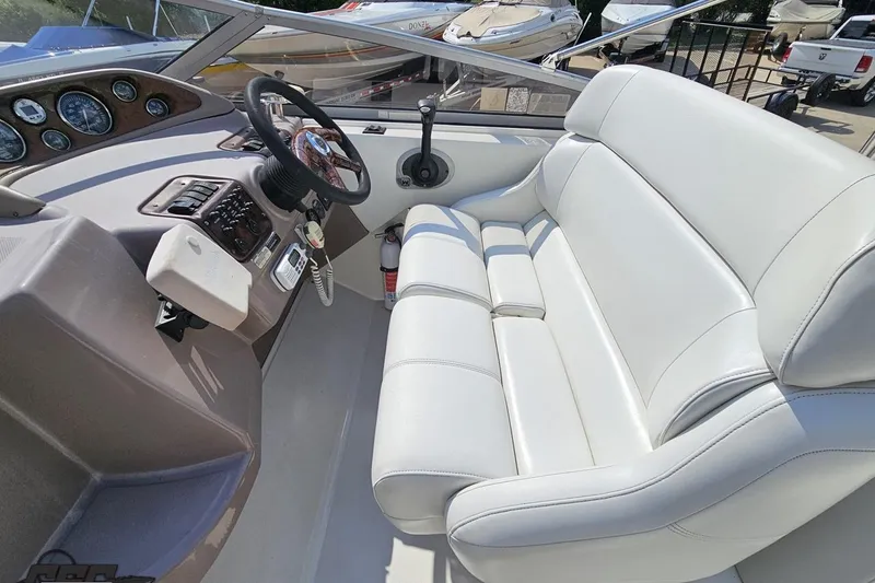 Slide: The Image of Interior of a 2003 Regal Commodore 2665 boat with white seating and control panel. - 47