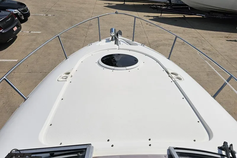 Slide: The Image of 2003 Regal Commodore 2665 boat deck with railing and hatch, parked on concrete. - 52