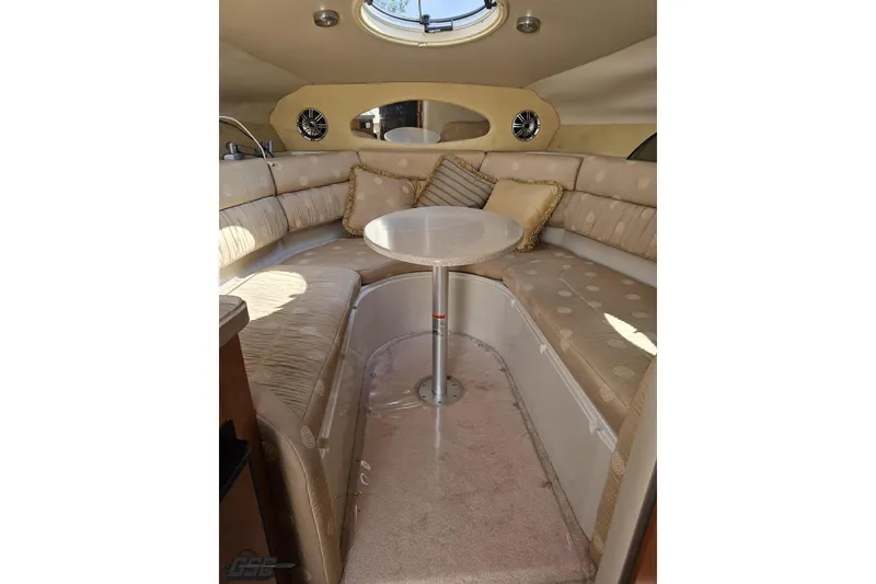 Slide: The Image of 2003 Regal Commodore 2665 cabin interior with beige seating and round table. - 54