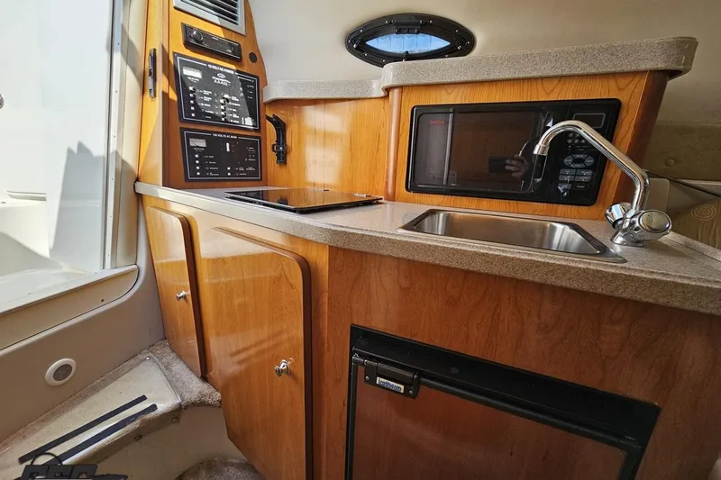 Slide: The Image of 2003 Regal Commodore 2665 boat interior with kitchenette, sink, and microwave. - 58