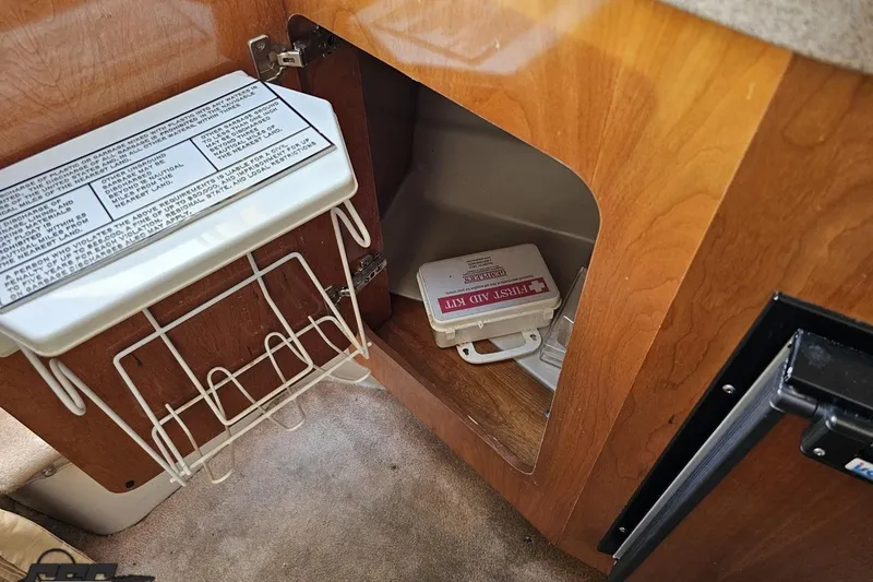 Slide: The Image of 2003 Regal Commodore 2665 interior with first aid kit in wooden cabinet. - 63