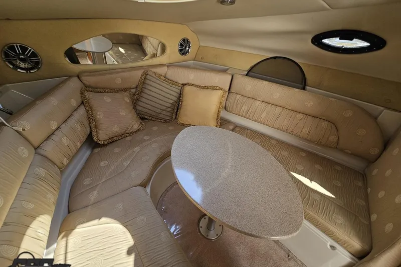 Slide: The Image of Interior of 2003 Regal Commodore 2665 boat with beige seating and oval table. - 64