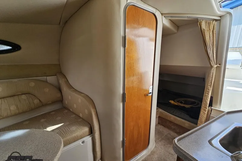 Slide: The Image of Interior of 2003 Regal Commodore 2665 boat, featuring cozy seating and compact cabin space. - 65