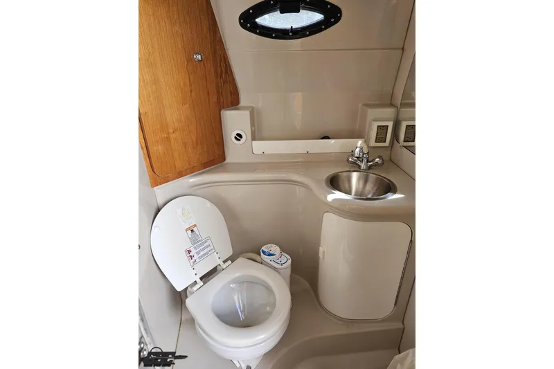 Slide: The Image of 2003 Regal Commodore 2665 boat bathroom with toilet, sink, and wooden cabinet. - 66