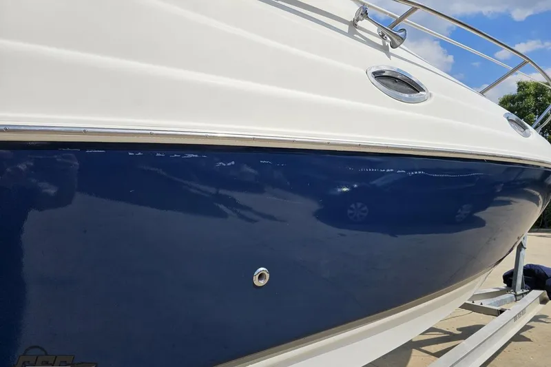 Slide: The Image of 2003 Regal Commodore 2665 boat, blue and white hull, docked under clear sky. - 7