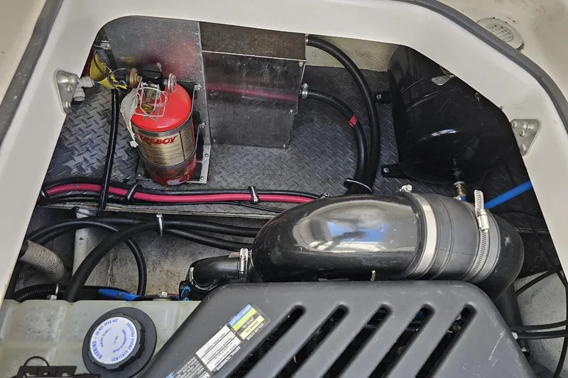 Slide: The Image of Engine compartment of a 2003 Regal Commodore 2665 boat with fire extinguisher and hoses. - 77