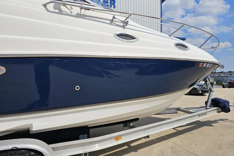 Slide: The Image of 2003 Regal Commodore 2665 boat on trailer, blue and white hull, sunny day. - 8