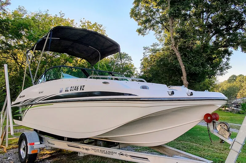 Slide: The Image of 2018 Hurricane SD187 boat on trailer, parked outdoors with trees in background. - 2