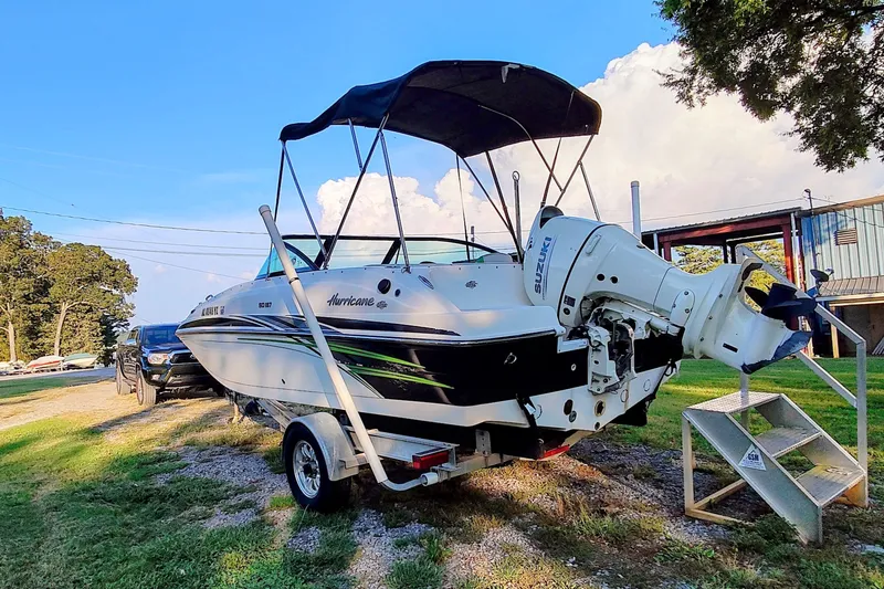 Slide: The Image of 2018 Hurricane SD187 boat with Suzuki outboard motor on a trailer, parked outdoors. - 3
