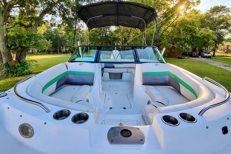 Slide: The Image of 2018 Hurricane SD187 boat with spacious seating, cup holders, and canopy, set in a lush green environment. - 5