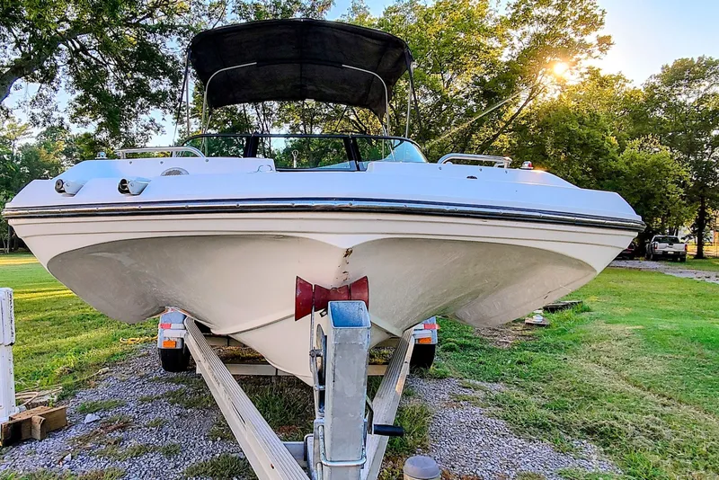 Slide: The Image of 2018 Hurricane SD187 boat on trailer, parked on grassy area with trees in background. - 6